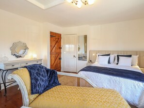 Une chambre avec deux lits, une commode, un miroir et une porte.