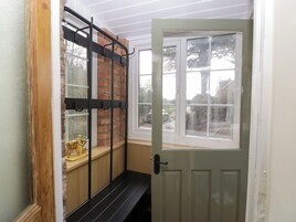 Una habitación con una banca, un ventanal con vistas al exterior y una puerta.