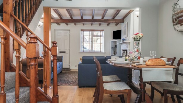 A dining area with a wooden table, chairs, and a loaf of bread.