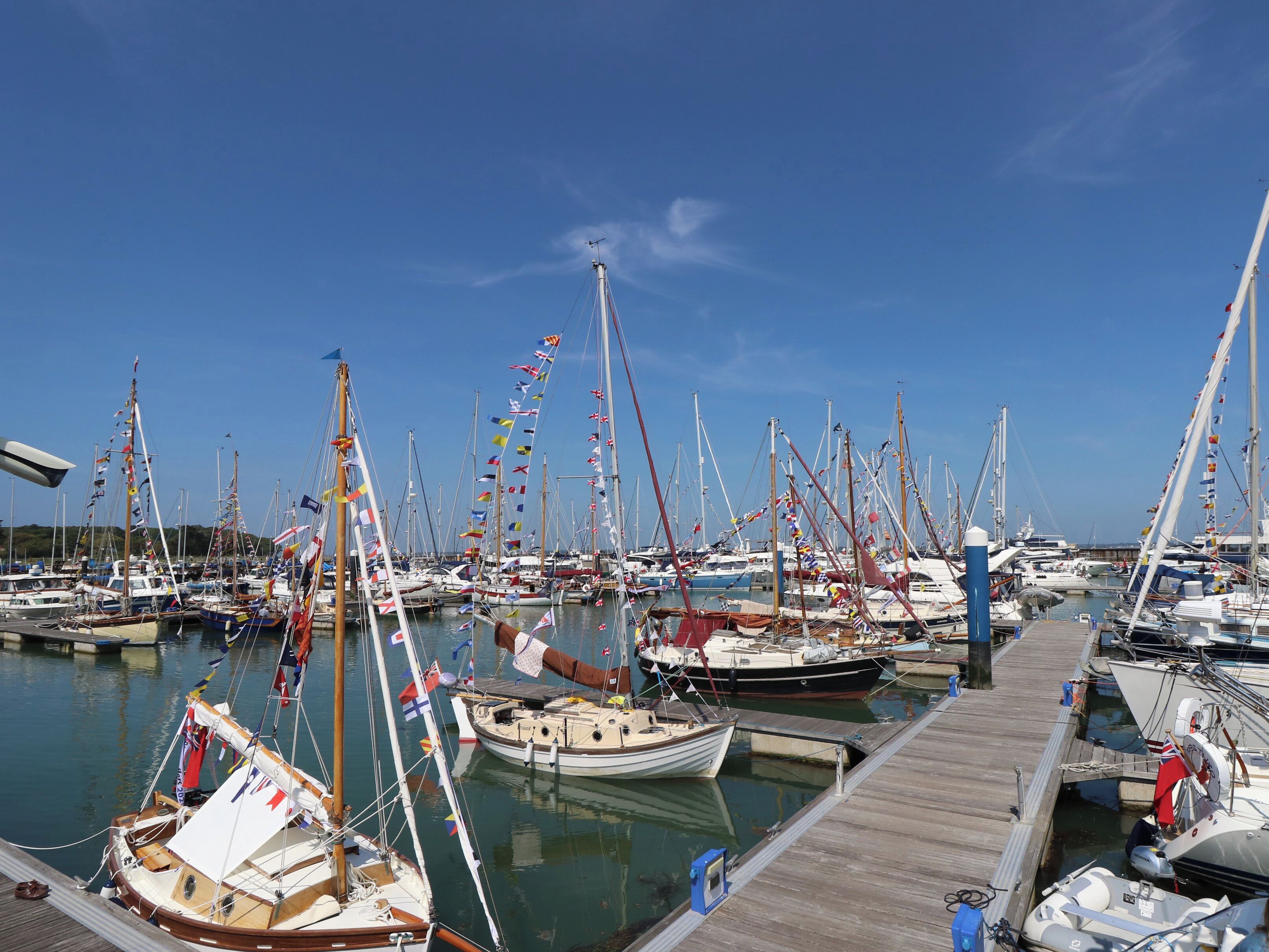 A marina with numerous boats docked at wooden piers.