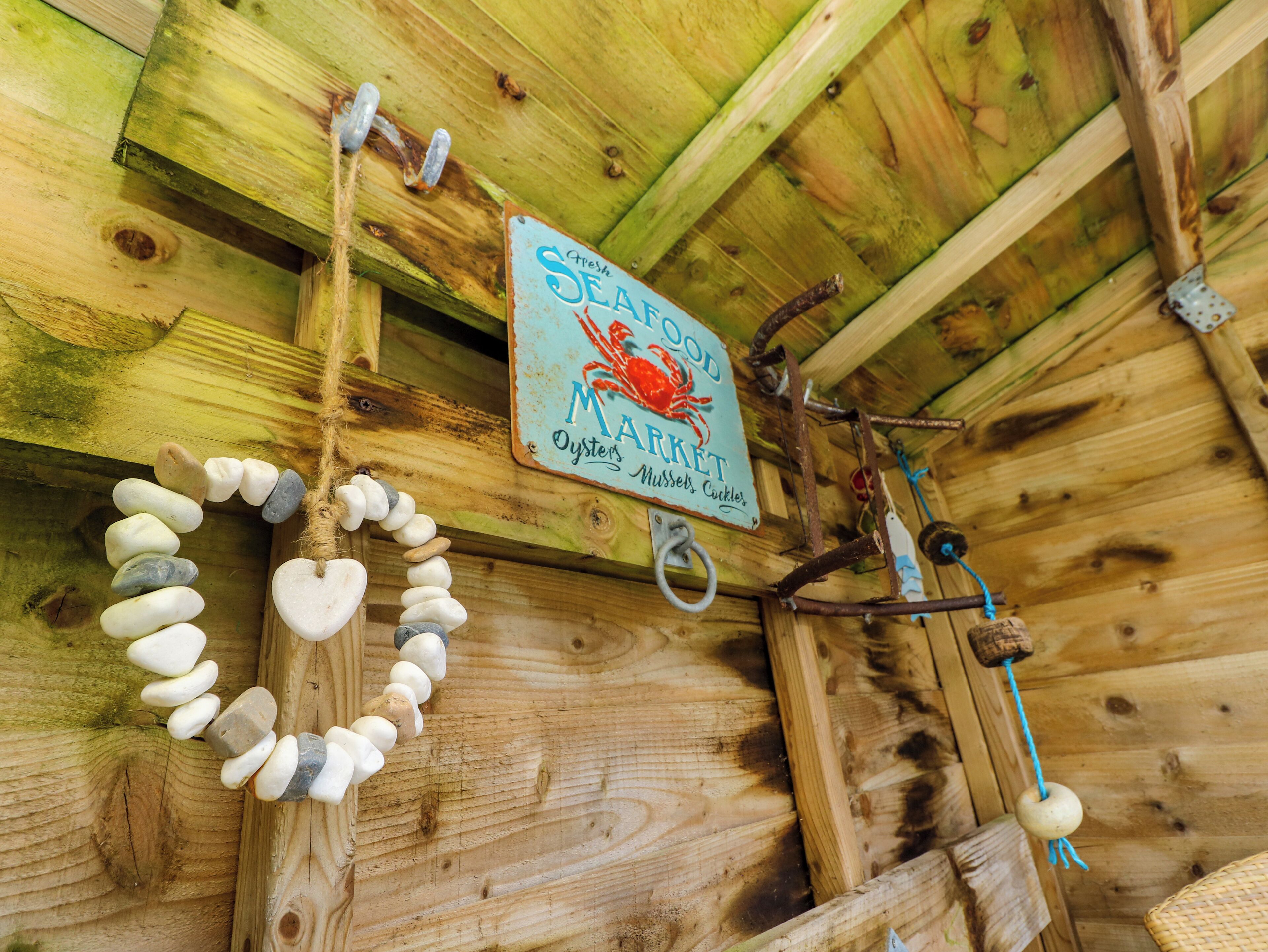 A rustic wooden ceiling with a sign reading "Fresh Seafood Market" and a decorative stone wall.