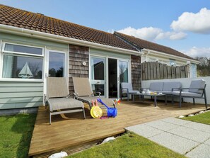 A house with a patio area featuring outdoor furniture, a wooden deck, and a fenced backyard. - Plimoth N9 (Yarmouth)