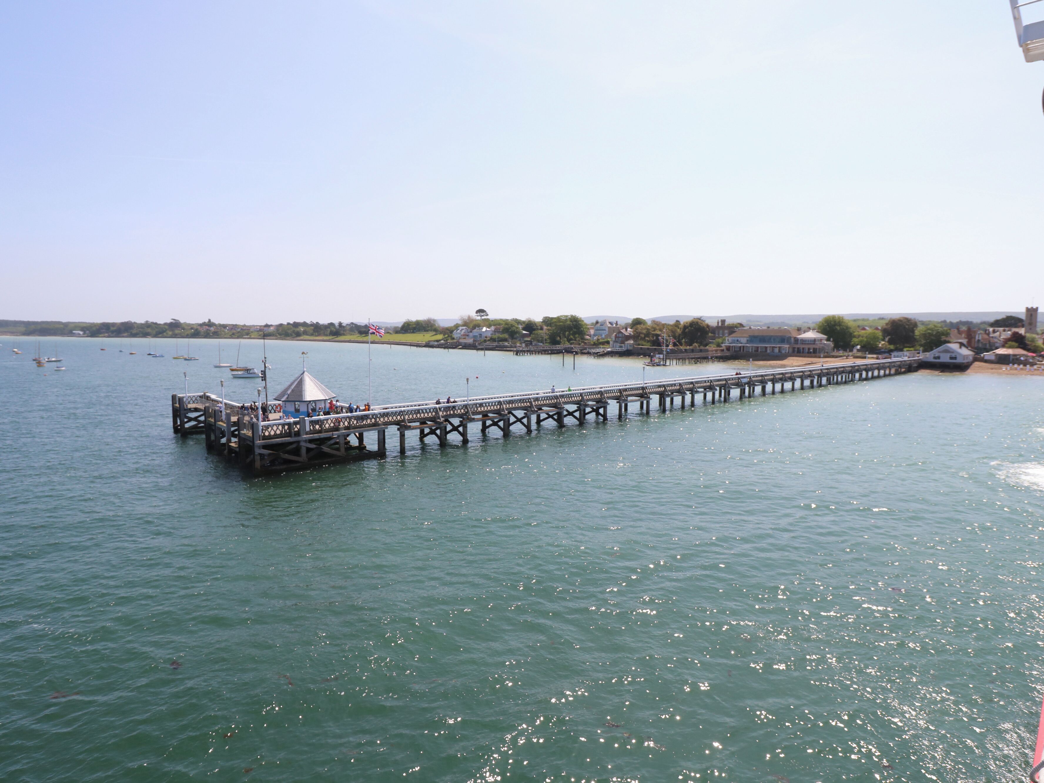 A pier extending into calm waters with a small gazebo at the end.