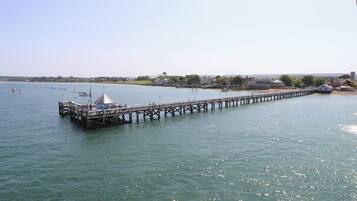 A pier extending into calm waters with a small gazebo at the end.