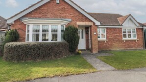 A two-story brick house with a bay window, a front door, and a small porch. - Bray Nook, 7 Craikewells (Bridlington)