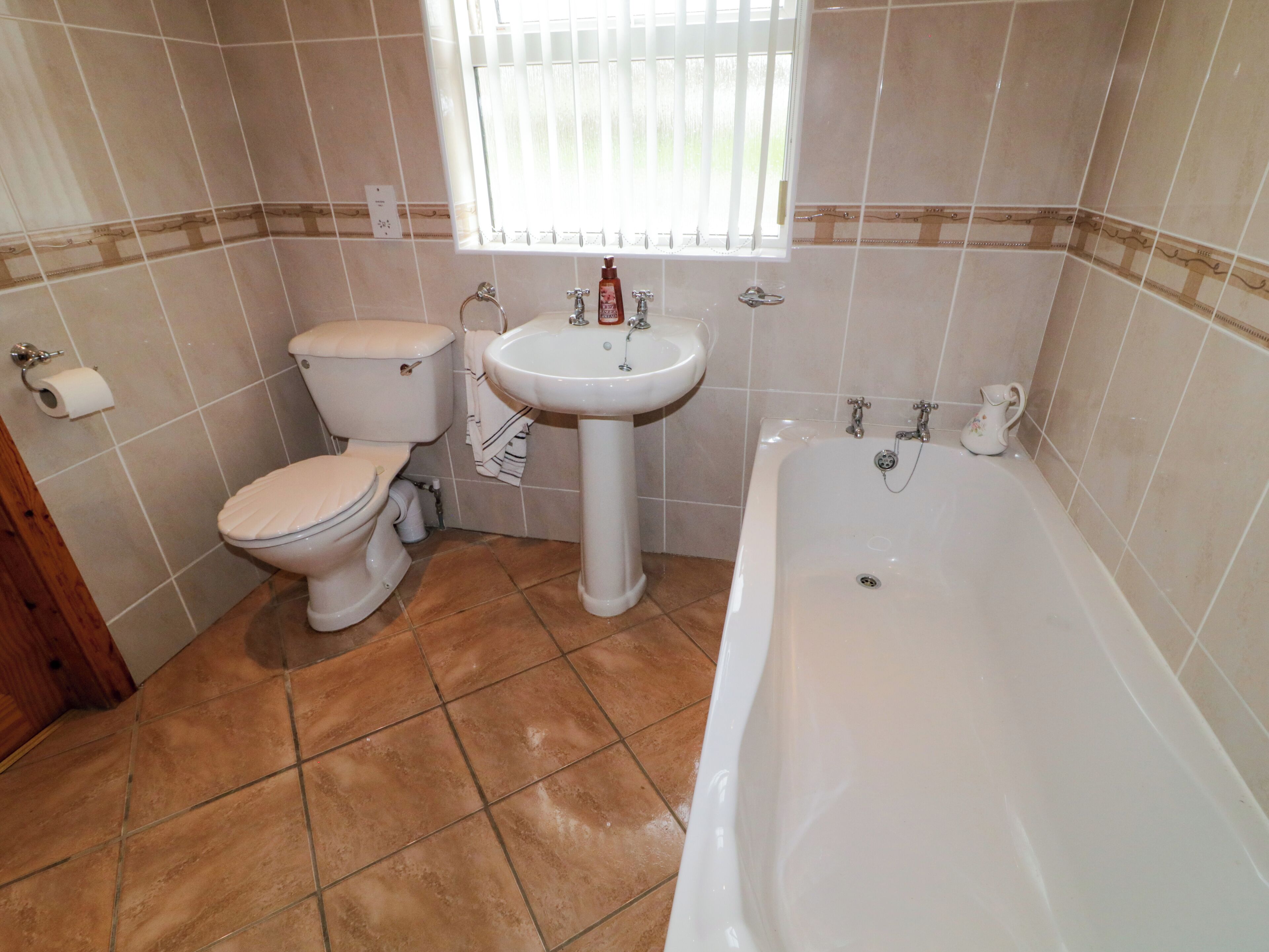 Un baño con inodoro, lavamanos y bañera.
