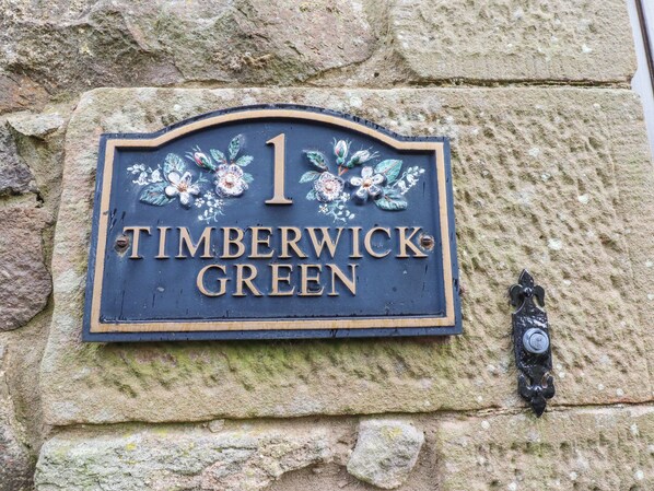 A house number sign with floral decorations and the text "1 TIMBERWICK GREEN". - Timberwick Green (Wooler)