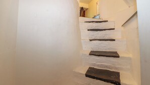 Una escalera con paredes blancas y escalones oscuros.