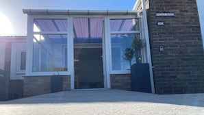 Un edificio moderno con un amplio acceso de vidrio, fachada de ladrillo y un letrero que dice "Villa Rose".