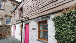 A traditional building with a white exterior, a wooden door, and a window. - Claire's Cottage (Bangor)