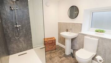 Un bagno moderno con doccia vetrata, lavabo bianco e servizi igienici.