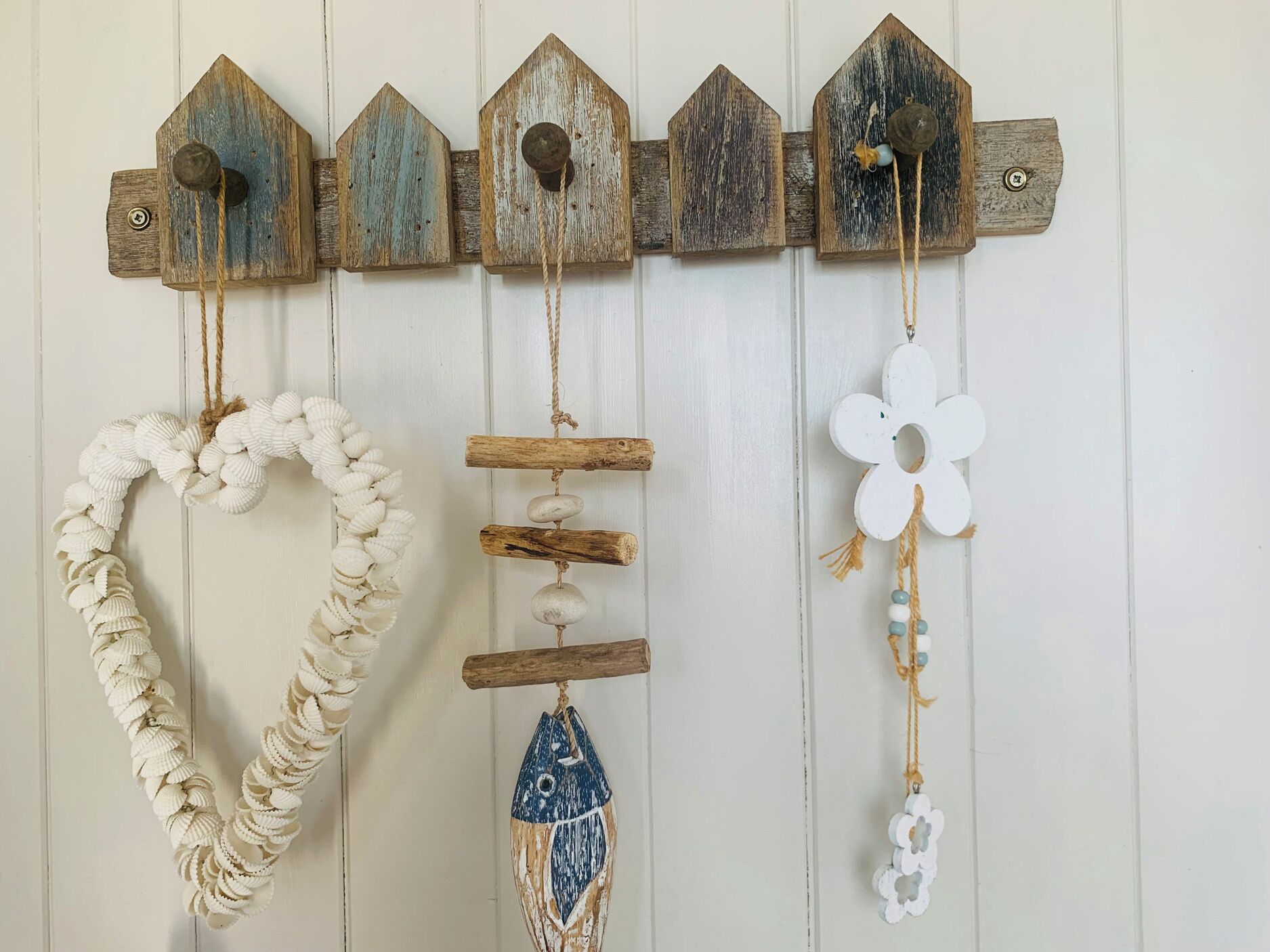 A wall-mounted decoration with a series of wooden houses and various hanging ornaments.