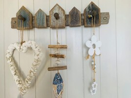 A wall-mounted decoration with a series of wooden houses and various hanging ornaments.