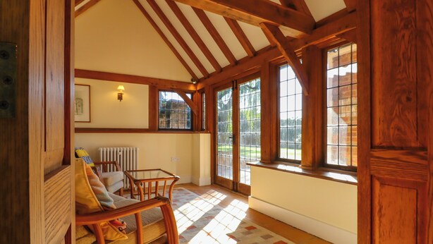 A spacious room with wooden beams, a large window, and a checkered floor. - New House Farm (Robertsbridge)