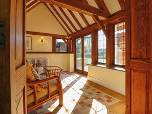 A spacious room with wooden beams, a large window, and a checkered floor. - New House Farm (Robertsbridge)