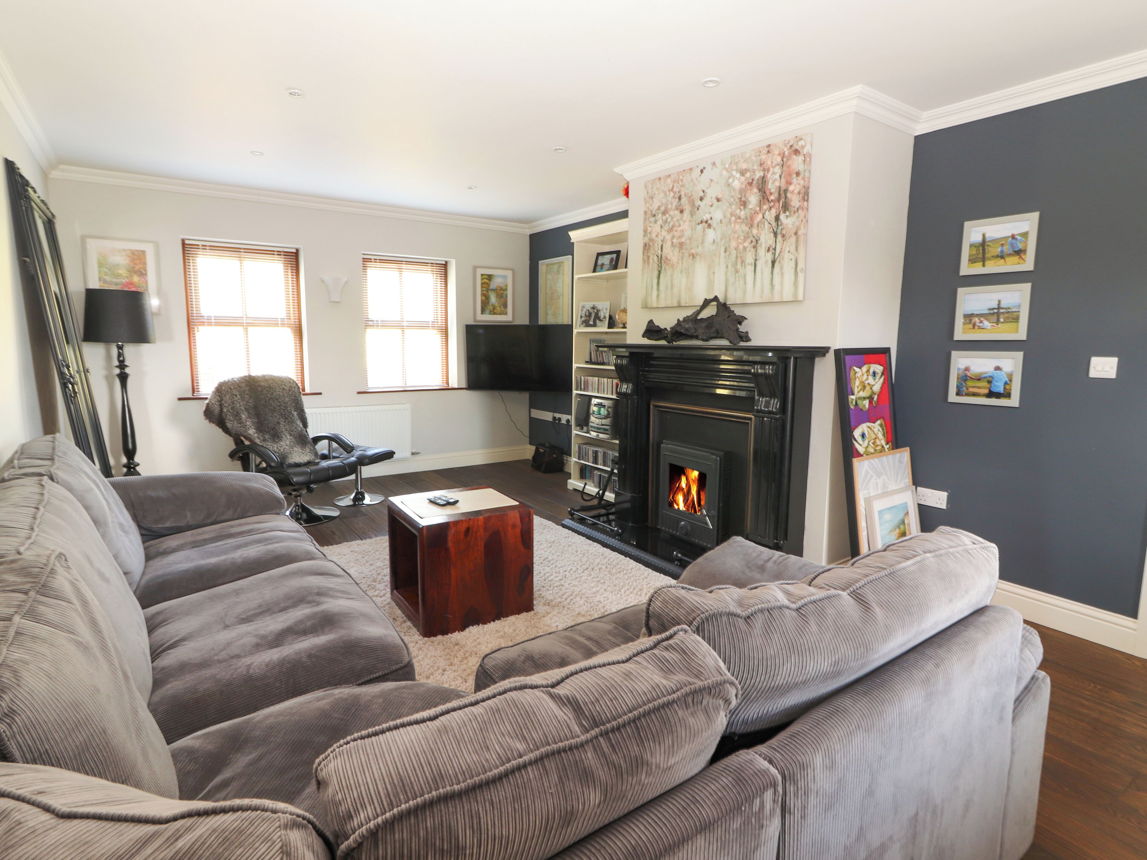 A living room with a fireplace, a sofa set, a coffee table, and a television.
