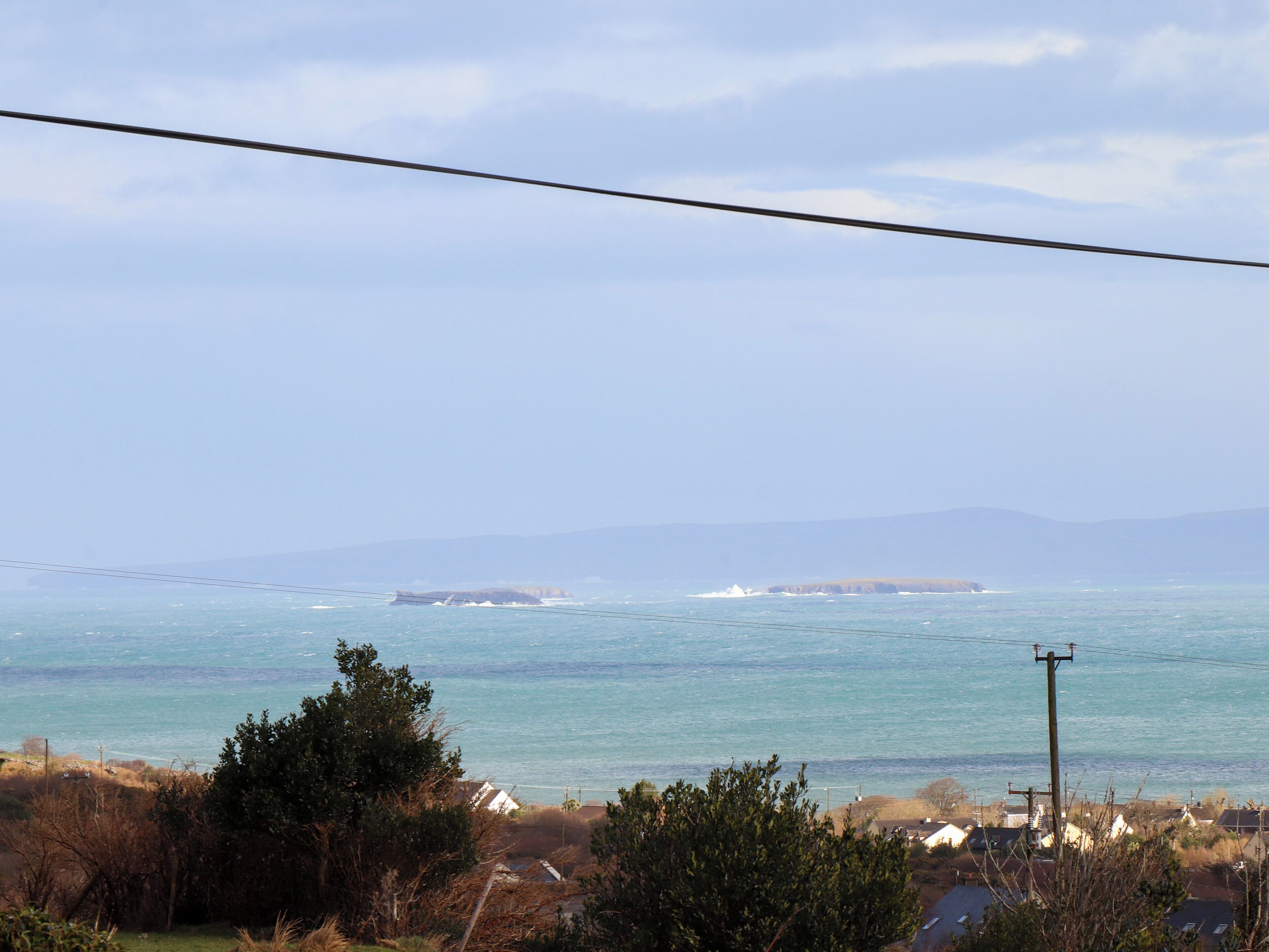 A coastal view with houses and a power line.