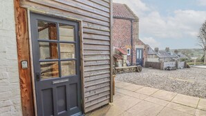 Une maison traditionnelle en bois avec une porte gris foncé portant l’inscription « SHEFFIELD COACH HOUSE ».