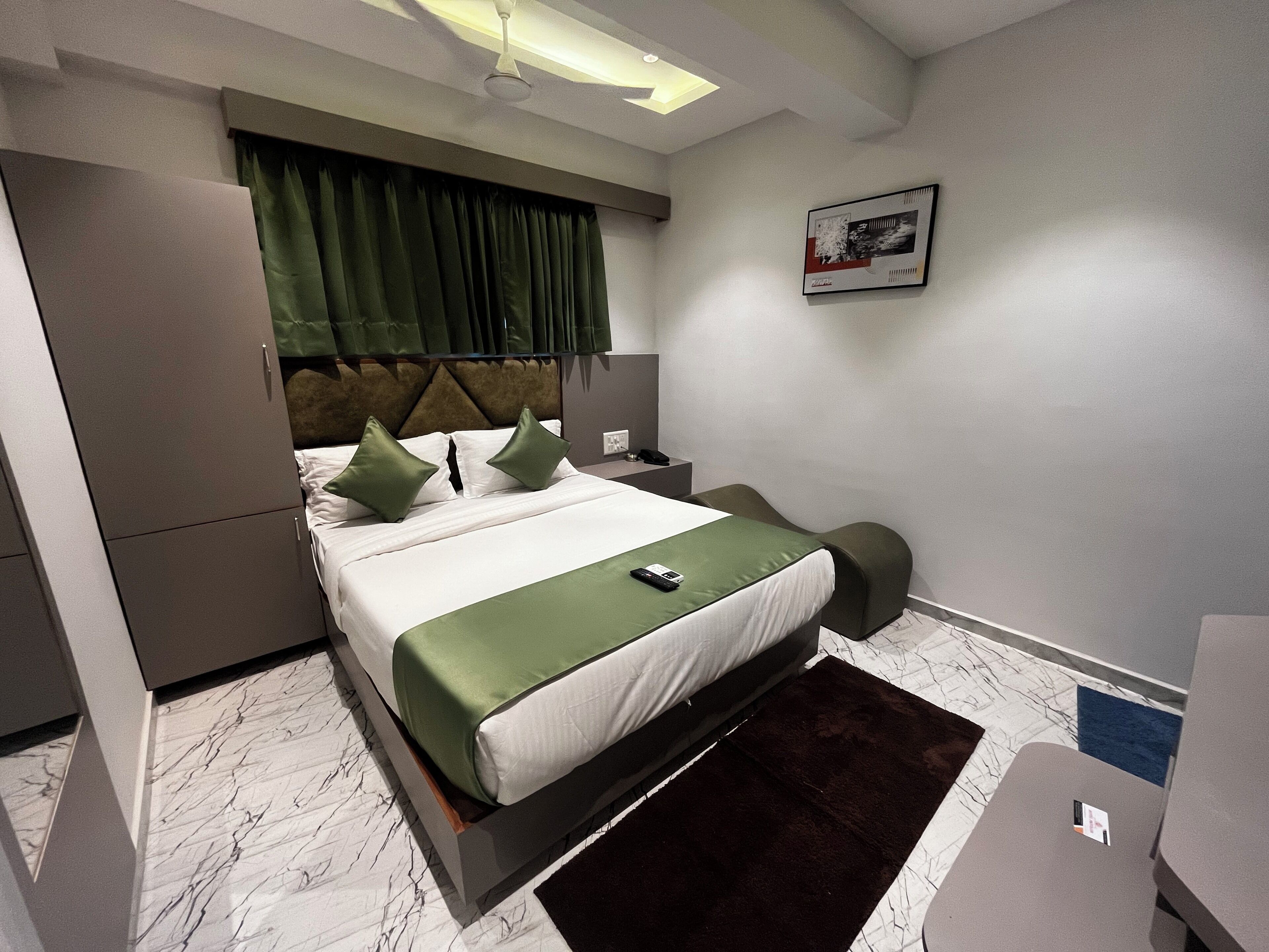 Ein modernes Hotelzimmer mit einem Bett, einem Schreibtisch und einem Stuhl.