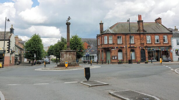A public square with a central monument, surrounding buildings, and a clear sky. - West Morton Suite (Thornhill)