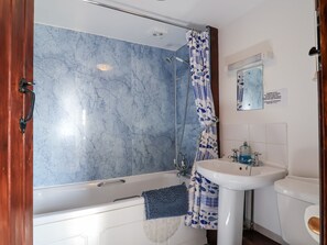 A bathroom with a bathtub, shower, and sink. - The Dairy (Liskeard)