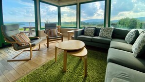 Un salón espacioso con un gran ventanal que ofrece una vista panorámica del campo.