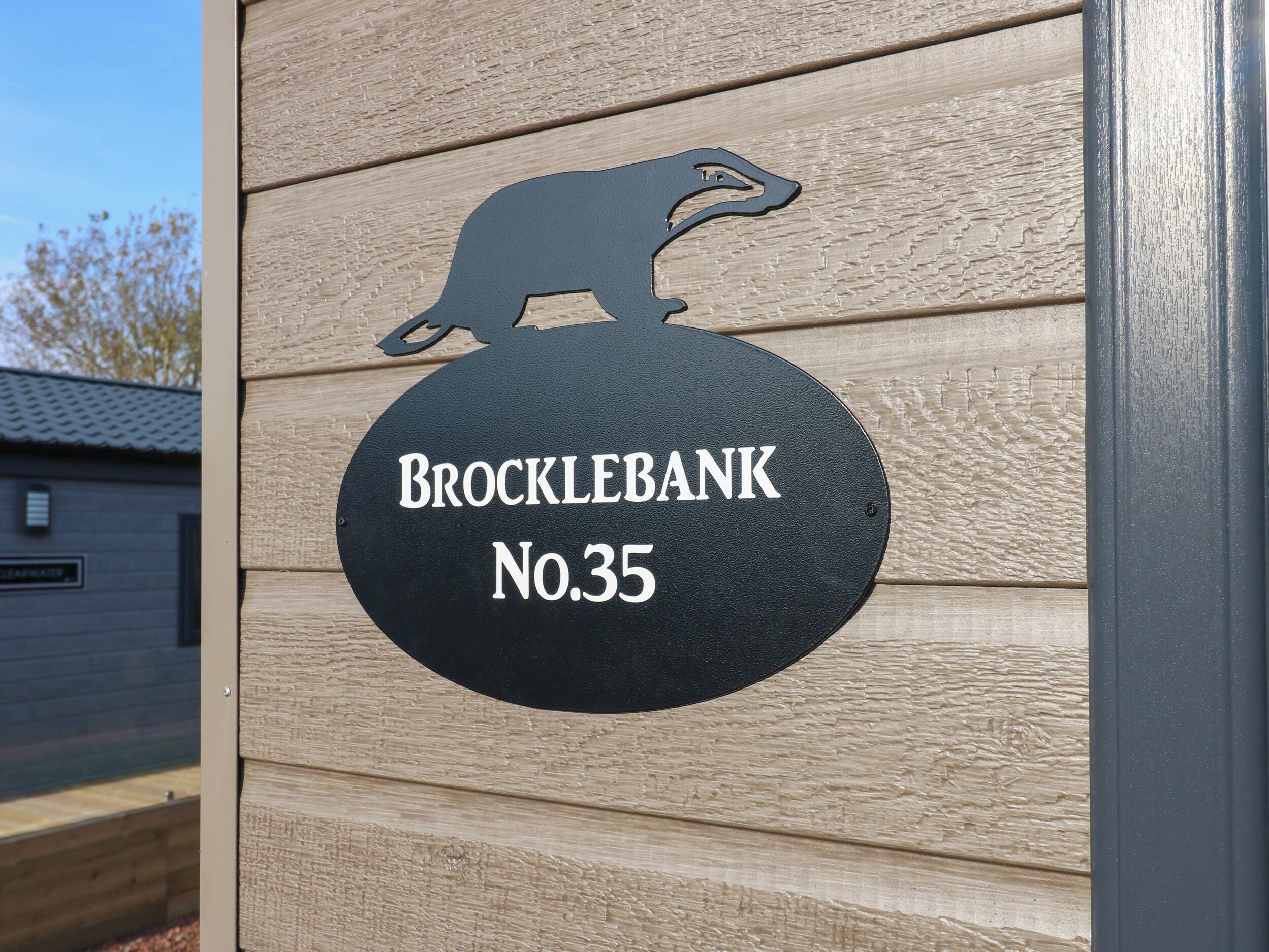 A black sign with a weasel silhouette and the text "Brocklebank No.35" on a wooden wall.