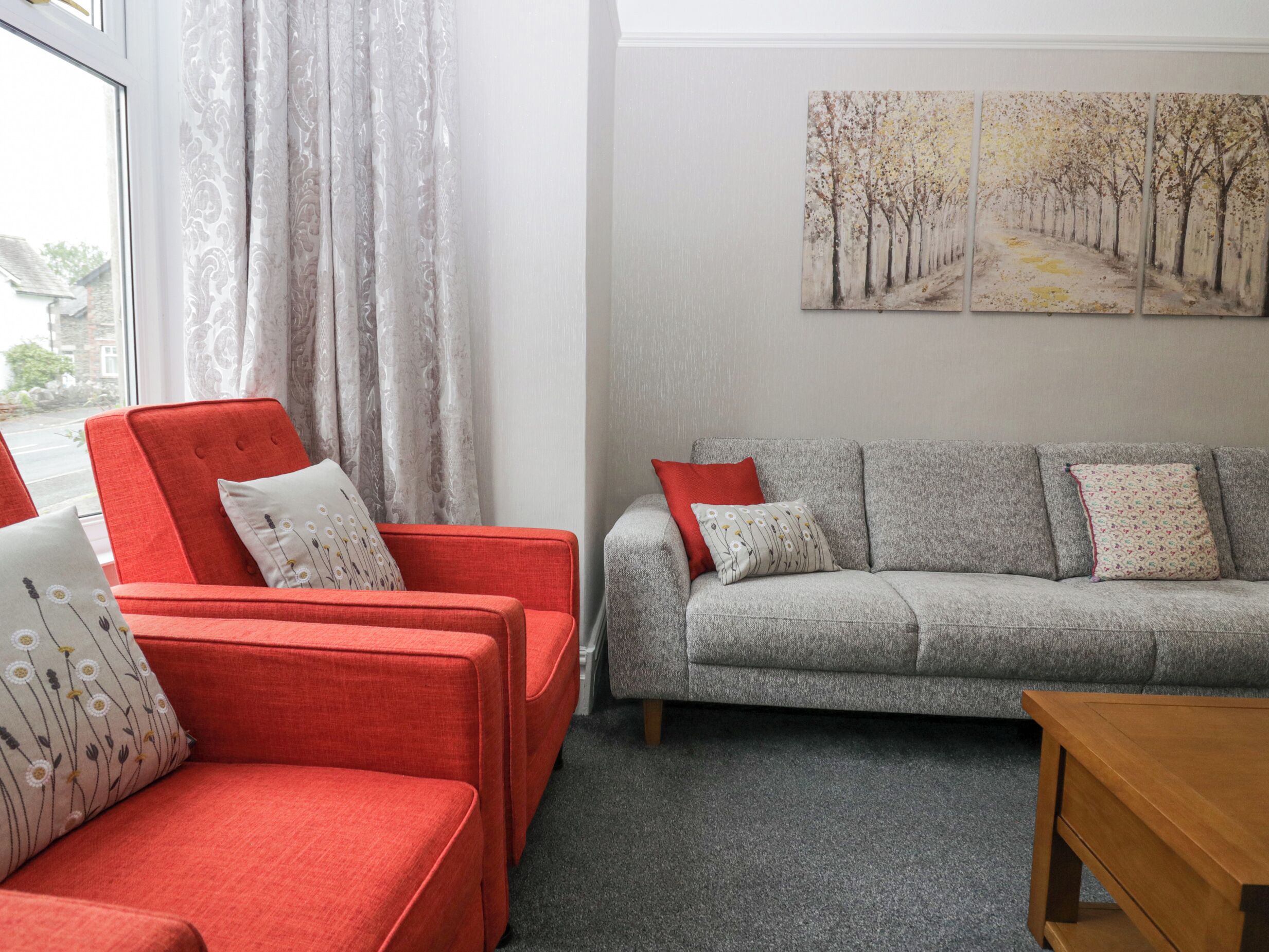 A living room with a red sofa, a grey sofa, and a wooden coffee table.