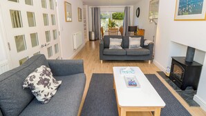A living room with a sofa, a coffee table, a fireplace, and a view of the outdoors. - Whitfield P10 (Yarmouth)