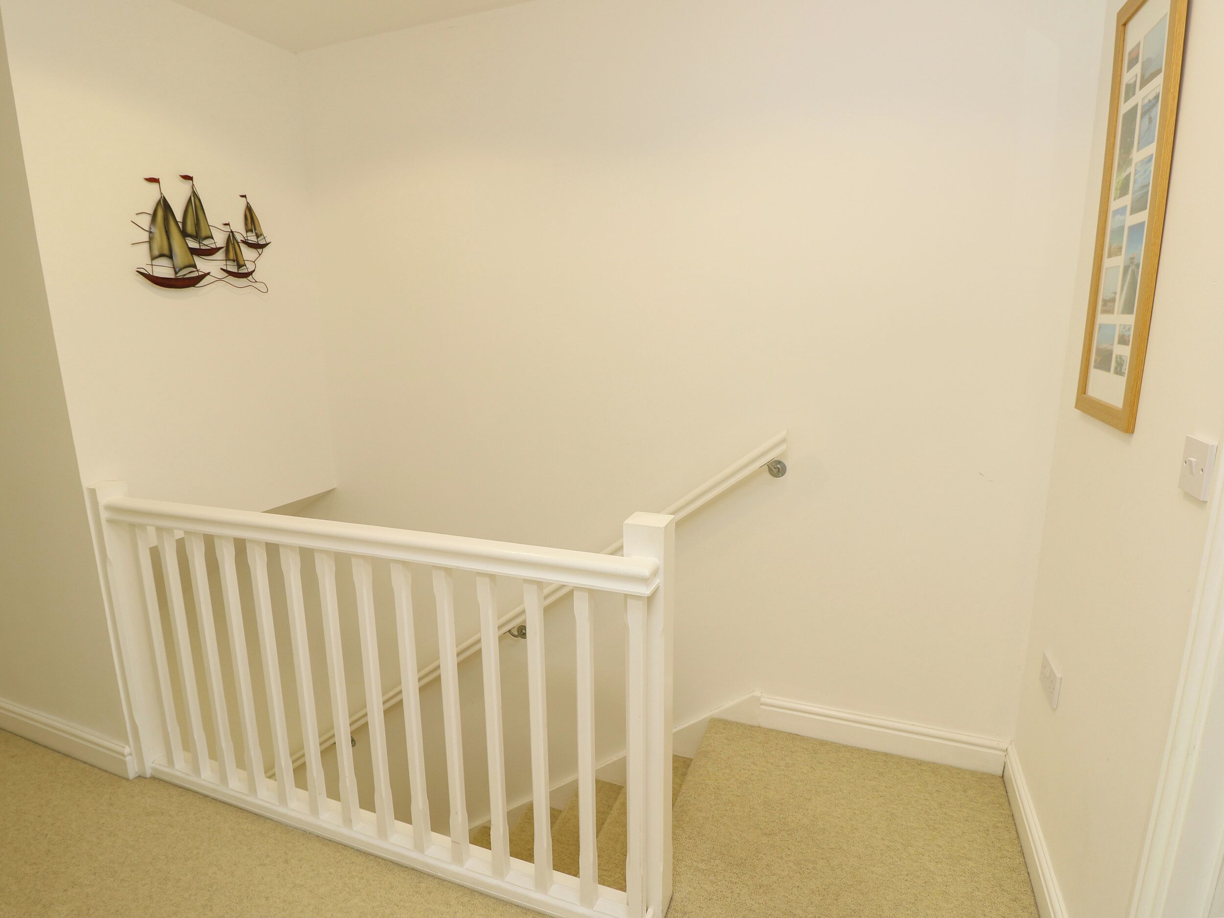 A staircase with a white railing leading to a landing.