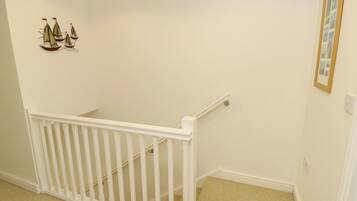 A staircase with a white railing leading to a landing.