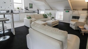 A modern loft apartment with a kitchen, living area, and a dining space. - The Old Workshop (Llanybydder)