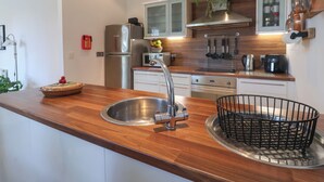 Une cuisine moderne dotée d’appareils électroménagers en acier inoxydable, d’un plan de travail en bois et d’un four encastré.