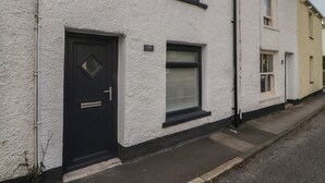Une rangée de maisons mitoyennes aux murs blancs, aux portes noires et aux fenêtres dotées de volets.