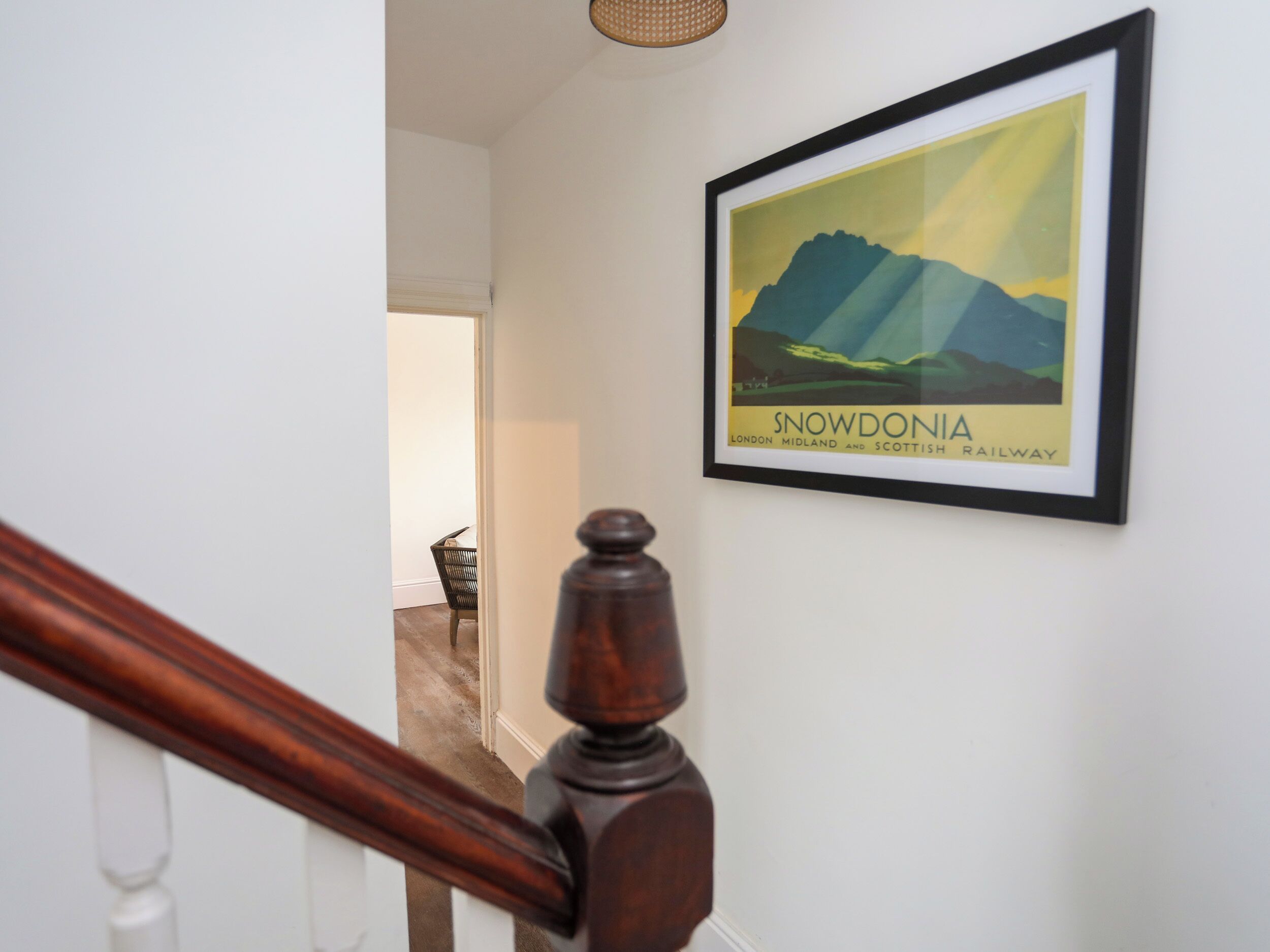 A framed poster of Snowdonia on a wall.
