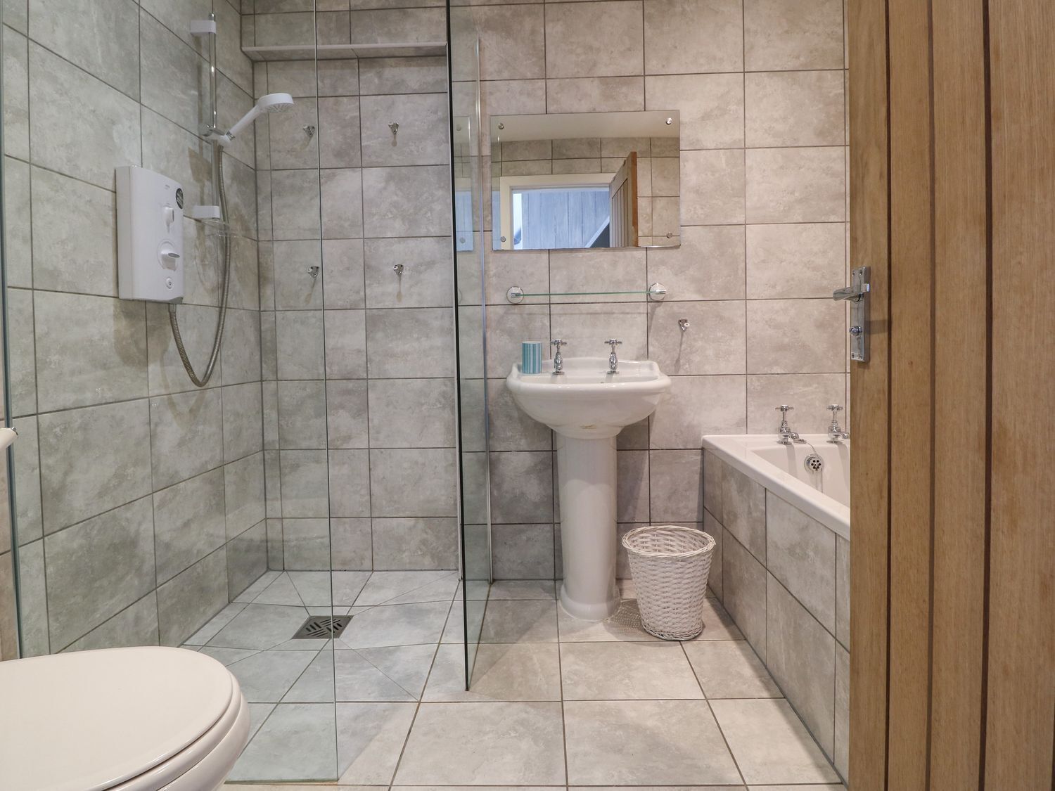 Un baño con ducha, lavamanos e inodoro.