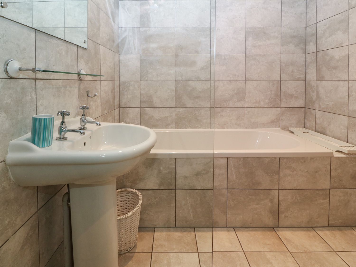 Un bagno con lavandino, rubinetto e vasca da bagno.