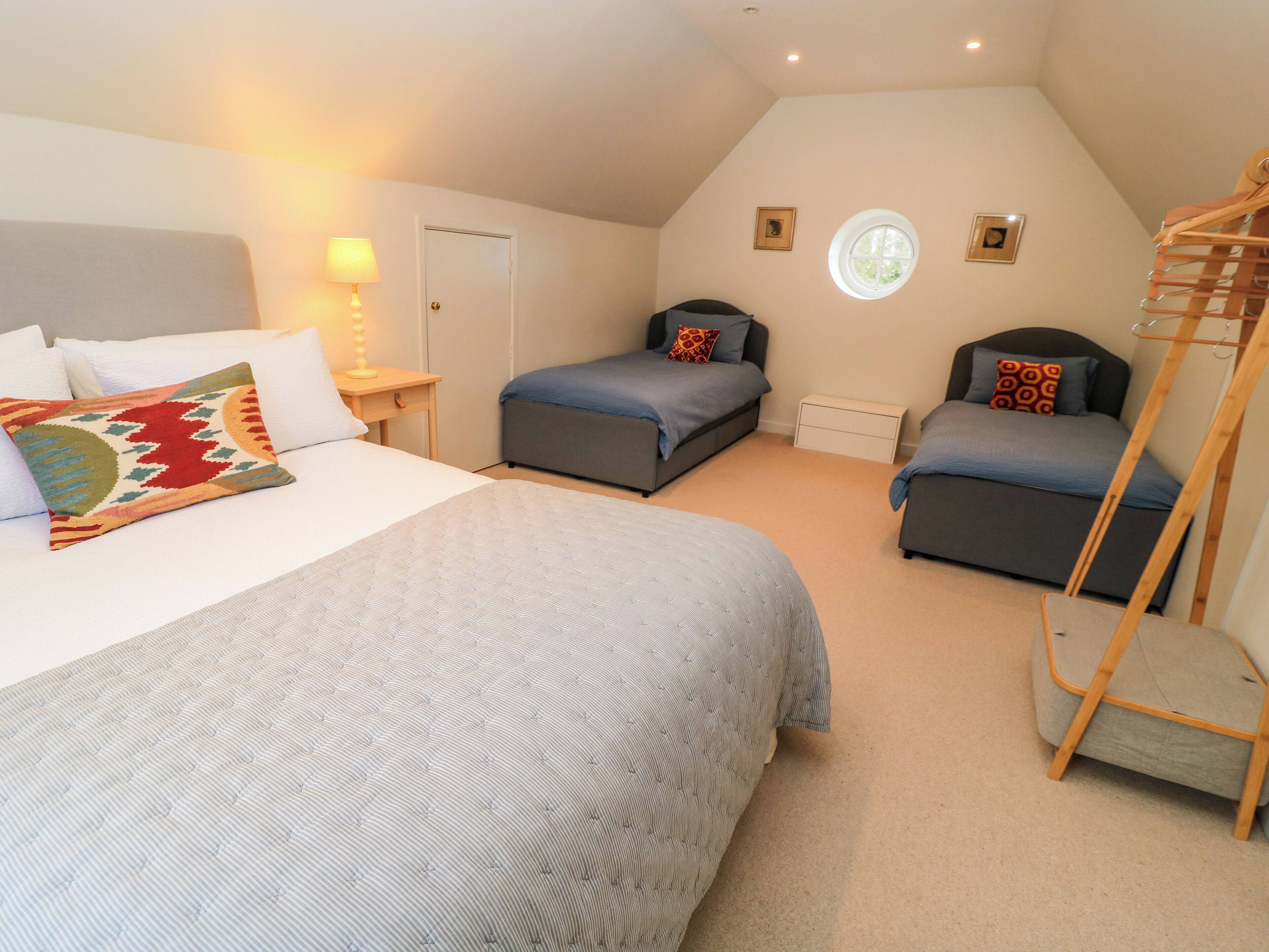 A bedroom with two beds, a window, and a wooden ladder.