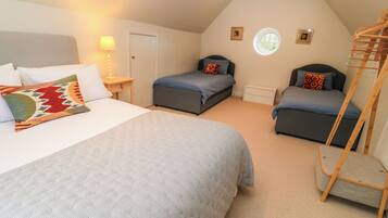 A bedroom with two beds, a window, and a wooden ladder.