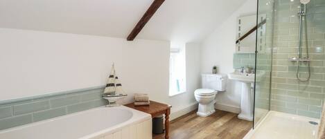 A bathroom with a bathtub, a toilet, a sink, and a shower area.