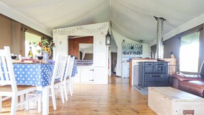 A rustic cabin interior with a dining area, kitchen, and seating space. - Bluebell (Penzance)