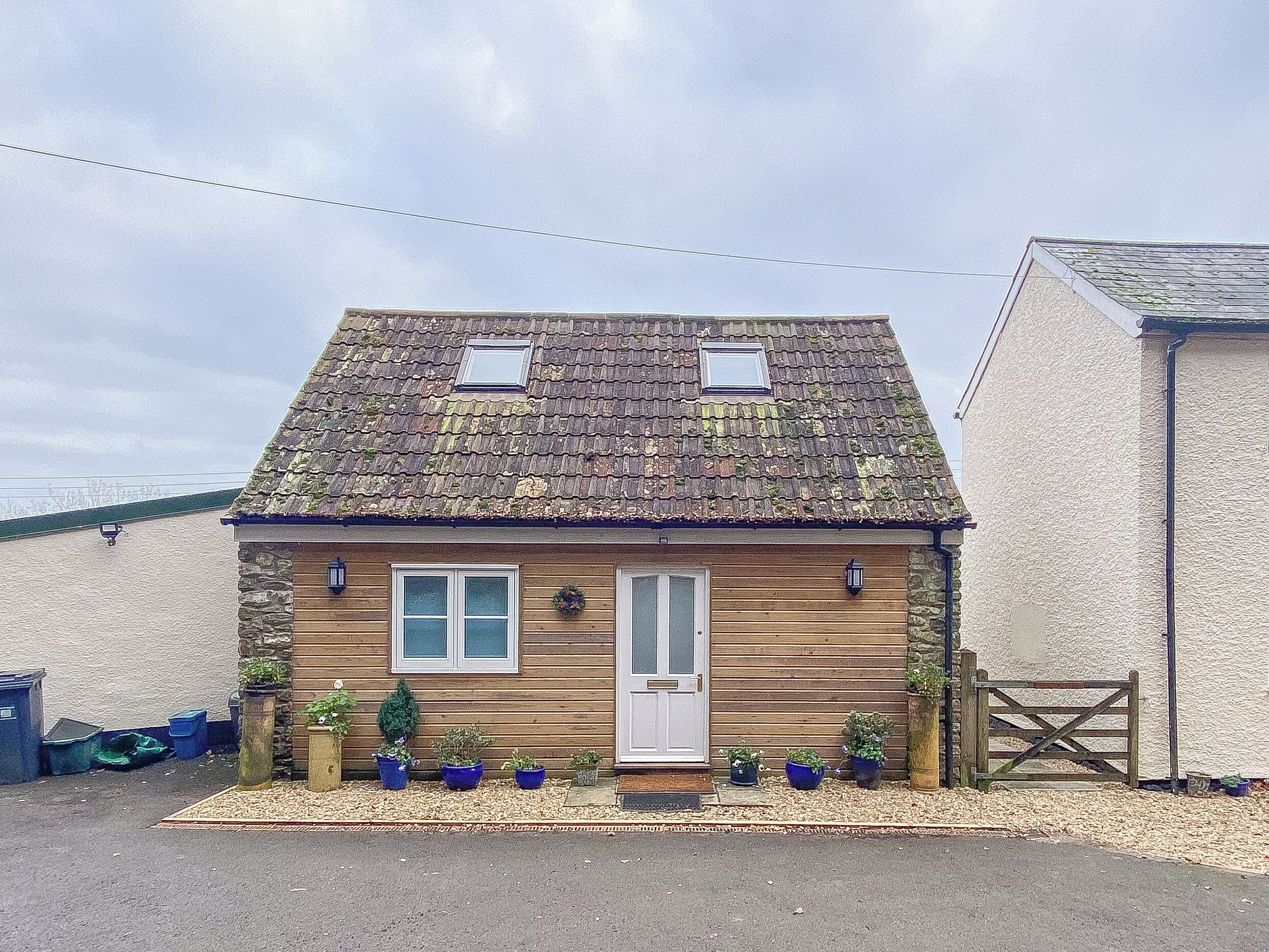 A small, single-story house with a sloped roof, a front door, and two windows.