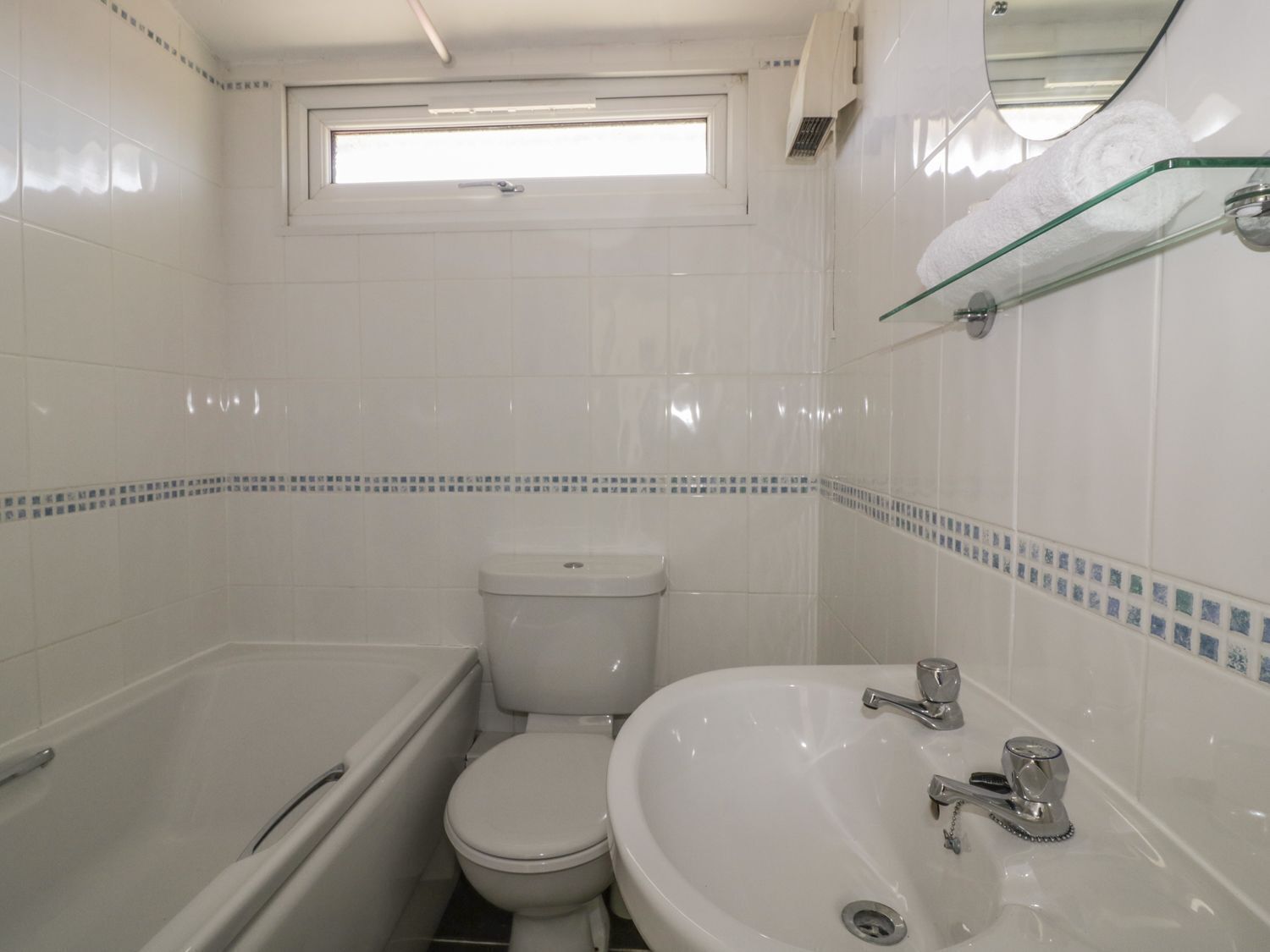 A bathroom with a bathtub, toilet, and sink.