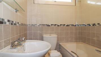 Ein Badezimmer mit Waschbecken, Toilette und Badewanne.