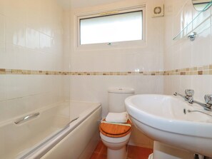 A bathroom with a bathtub, toilet, and sink.