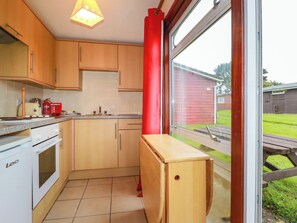 Een koelkast, een waterkoker, kookgerei, borden en bestek