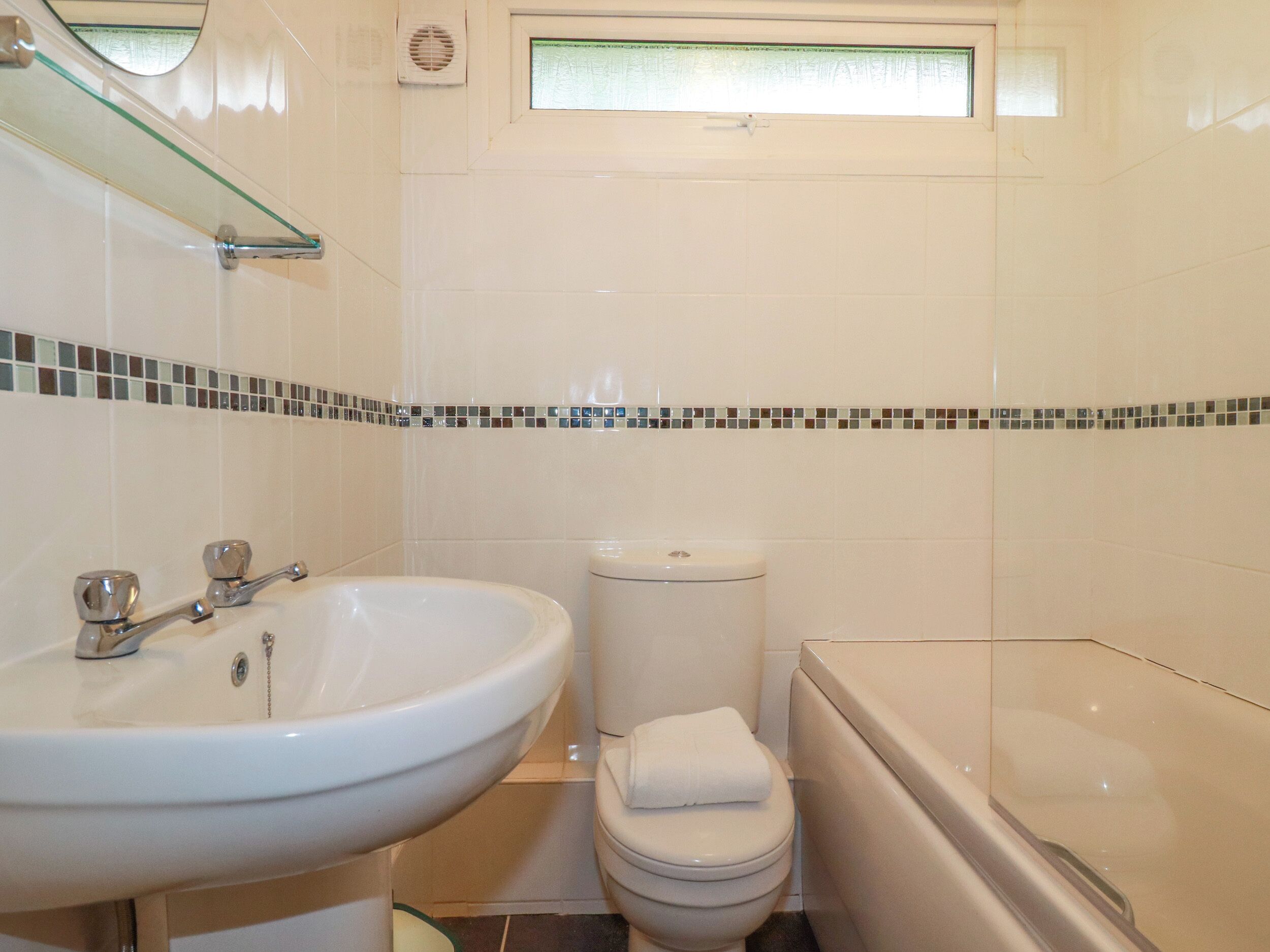 A bathroom with a sink, toilet, and bathtub.