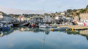 A harbor with boats docked, a pier, and buildings in the background. - Pepper Cove (Wadebridge)