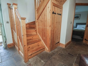 A wooden staircase leading to a bedroom with a bed and a nightstand. - Horseshoe Cottage (Middlesbrough)