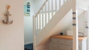 A staircase with white railings leading to a landing. - Old Police House (Salcombe)